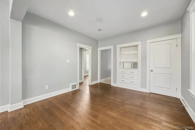 a view of an empty room with wooden floor