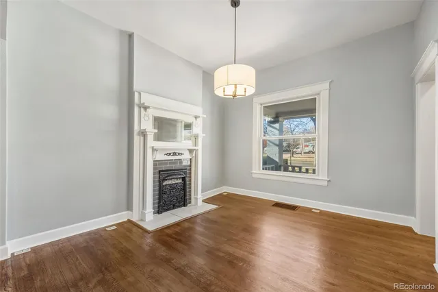 a view of an empty room with a kitchen and wooden floor