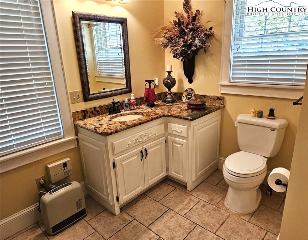 11644 Highway 88 Creston, NC 28615 - Photo 25 of 50 a bathroom with a granite countertop toilet sink and mirror