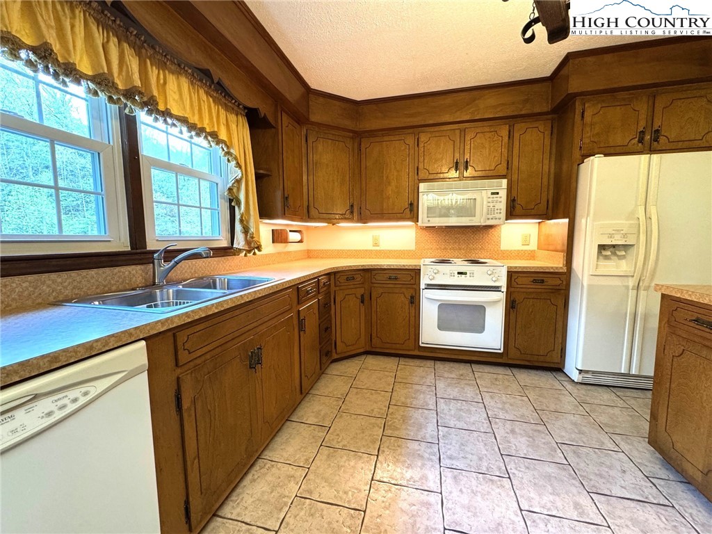 11644 Highway 88 Creston, NC 28615 - Photo 28 of 50 a kitchen with a sink a refrigerator and cabinets