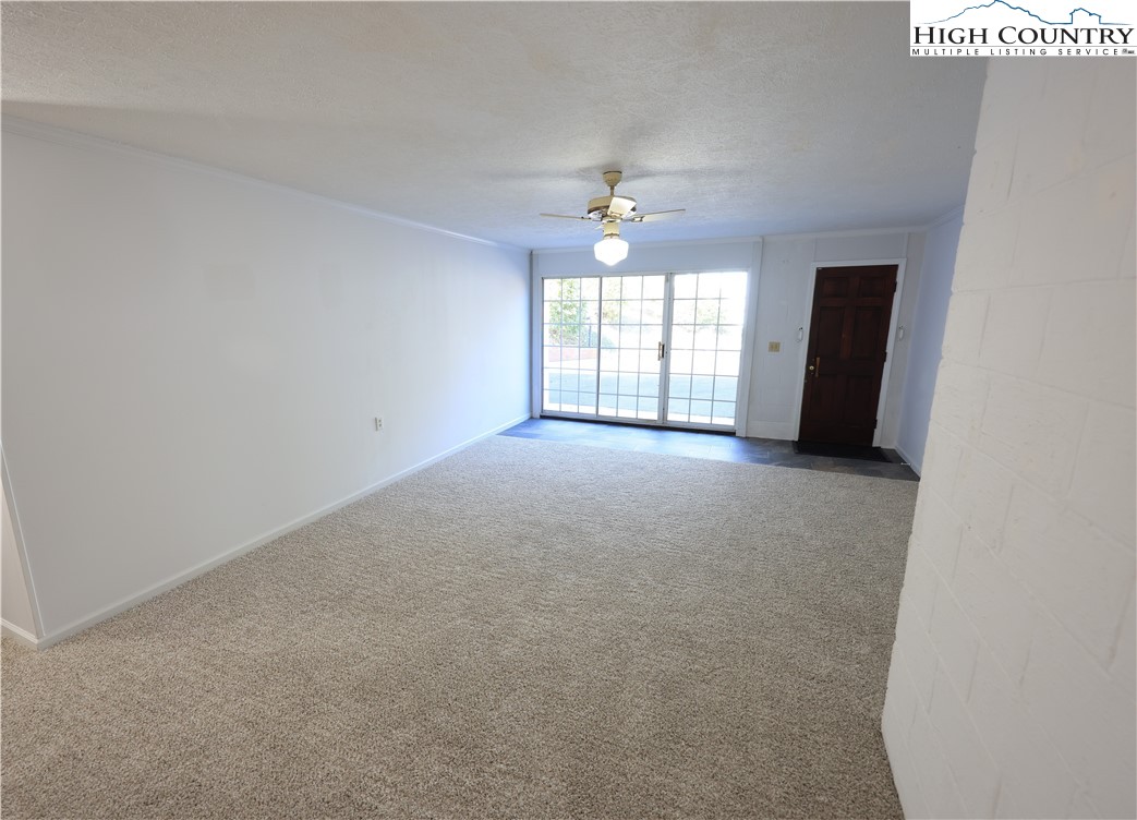 11644 Highway 88 Creston, NC 28615 - Photo 45 of 50 an empty room with windows and chandelier fan