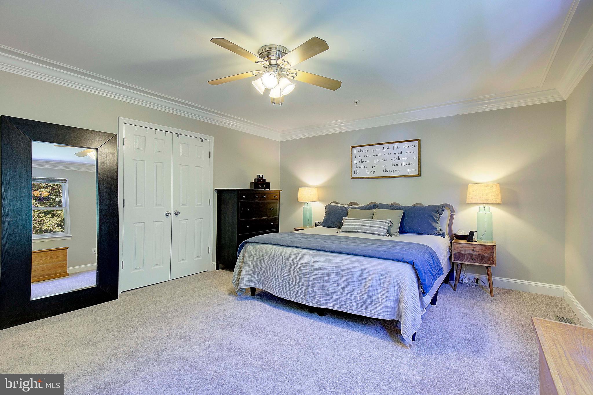 7006 Prout Road Friendship, MD 20758 - Photo 18 of 48 a spacious bedroom with a bed and a chandelier