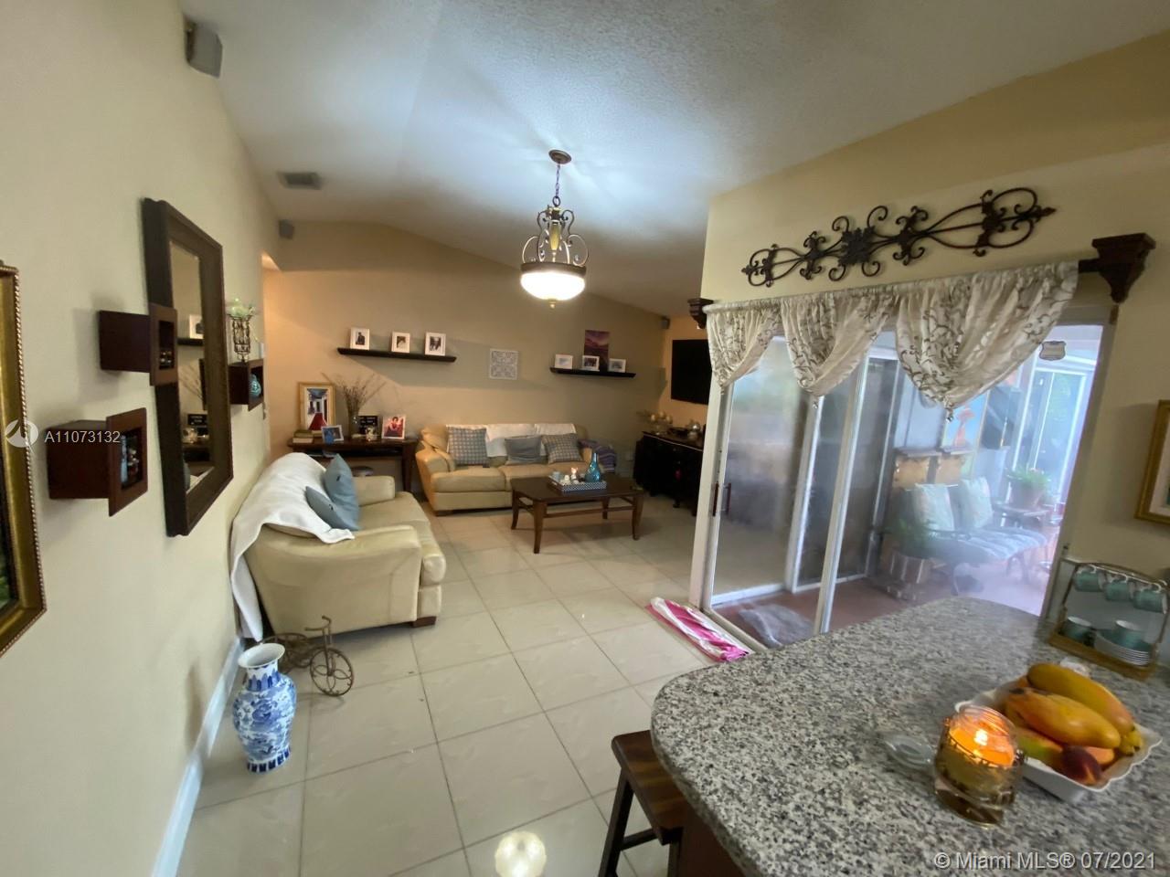 12374 Southwest 197th Terrace Miami, FL 33177 - Photo 7 of 13 a living room with furniture and a chandelier
