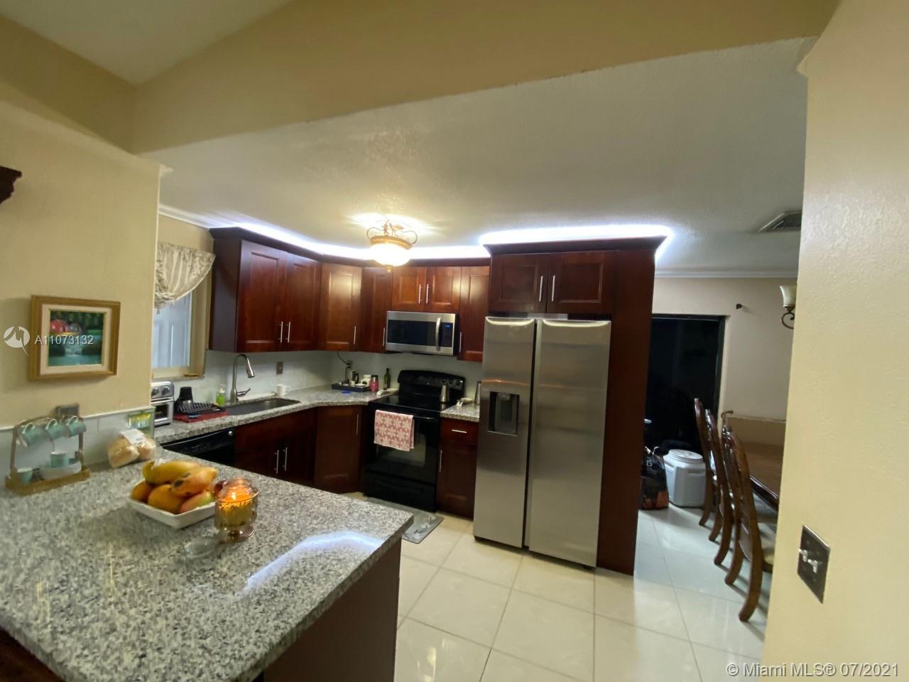 12374 Southwest 197th Terrace Miami, FL 33177 - Photo 8 of 13 a kitchen with stainless steel appliances granite countertop sink refrigerator and cabinets