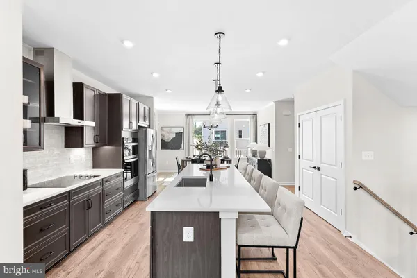 a large kitchen with kitchen island a stove a sink a dining table and chairs