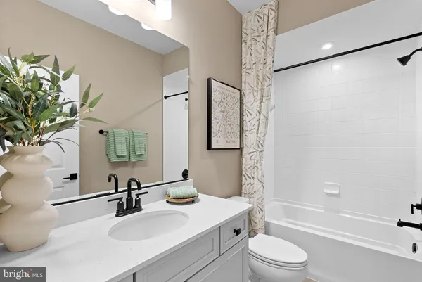 a bathroom with a sink a toilet a mirror a vanity and shower