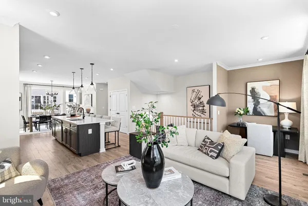 a living room with furniture potted plant and kitchen view