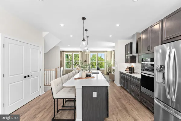a kitchen with a dining table chairs stainless steel appliances and cabinets