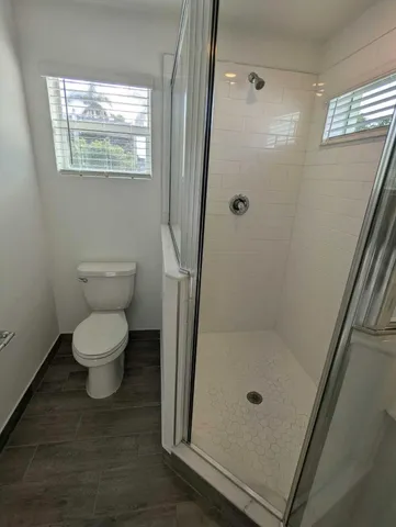 a bathroom with a toilet and a shower