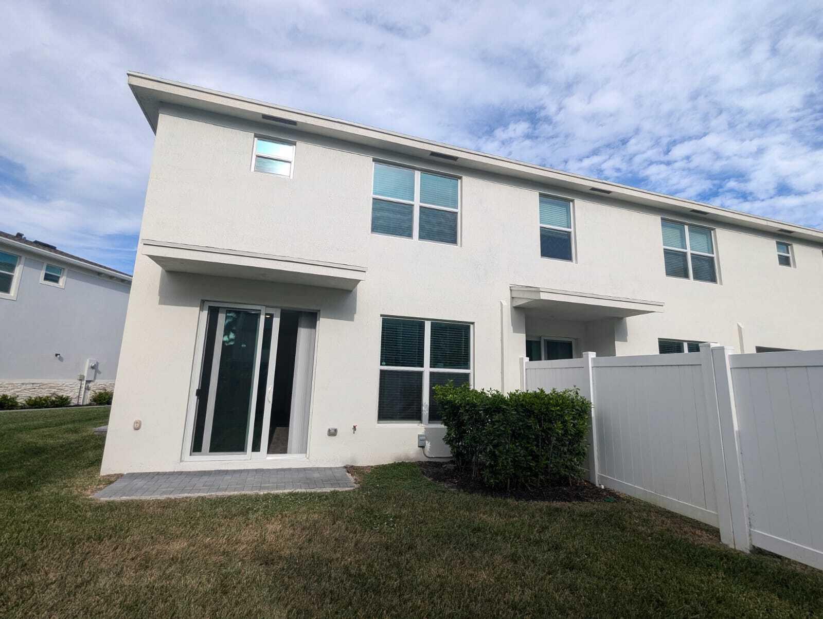 4351 Pond Lily Lane Lake Worth, FL 33467 - Photo 18 of 26 a view of a white house with a small yard and a large window