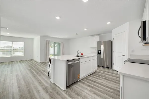 a kitchen with stainless steel appliances a stove top oven a refrigerator and cabinets