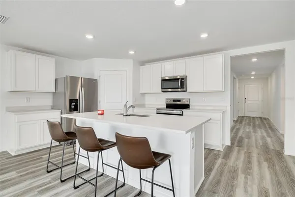 a kitchen with white cabinets and stainless steel appliances