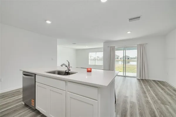 a kitchen with a sink and wooden floor