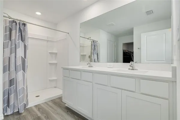 a bathroom with a shower sink and mirror