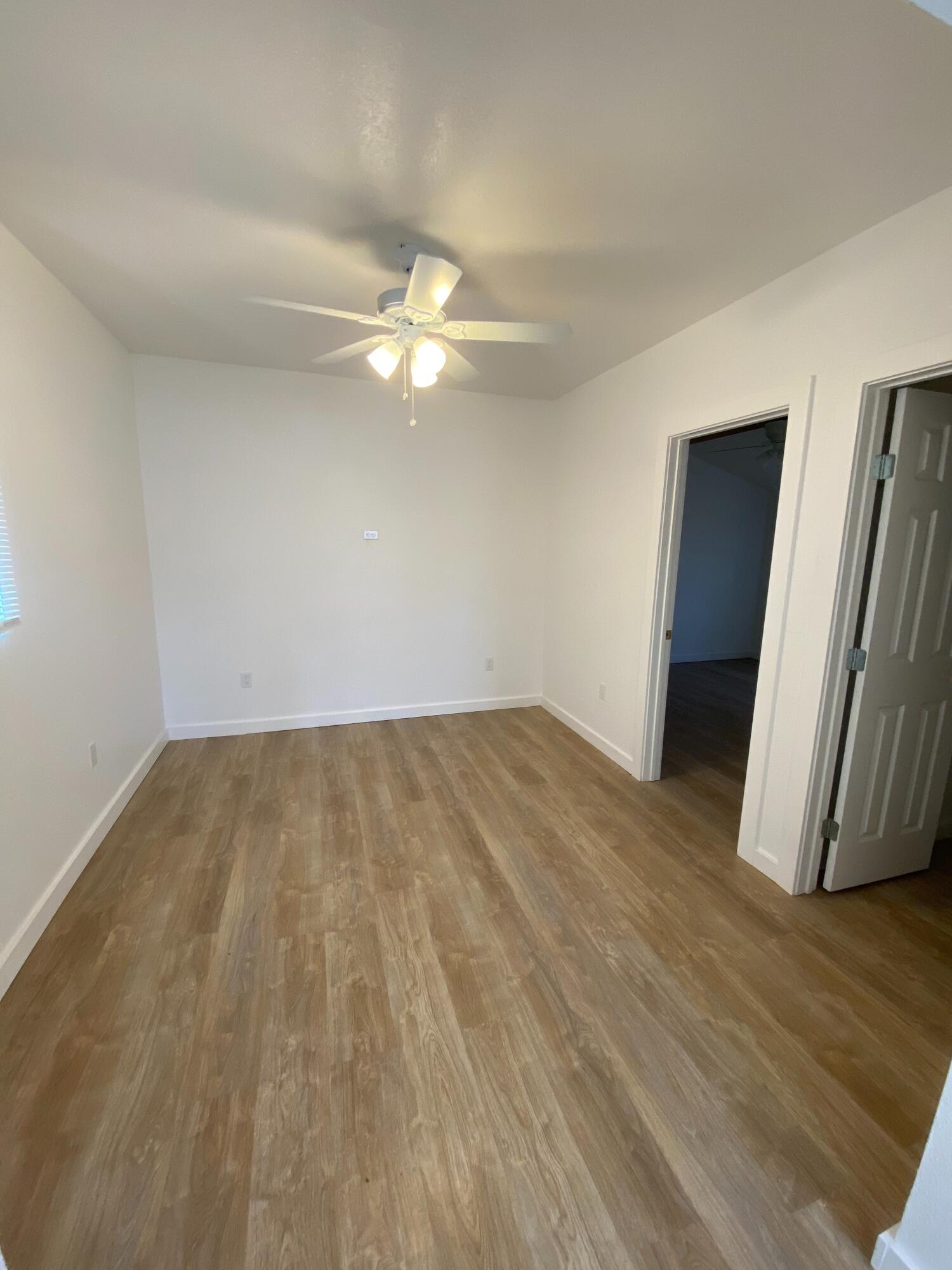 2017 17th Street, Unit REAR Lubbock, TX 79401 - Photo 6 of 9 an empty room with wooden floor and ceiling fan