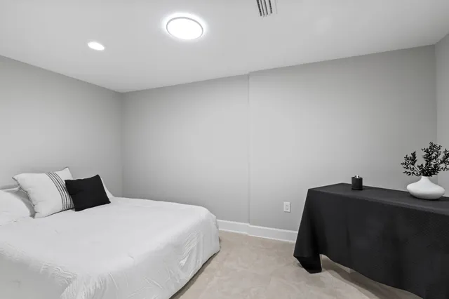 a spacious bedroom with a bed and a large mirror