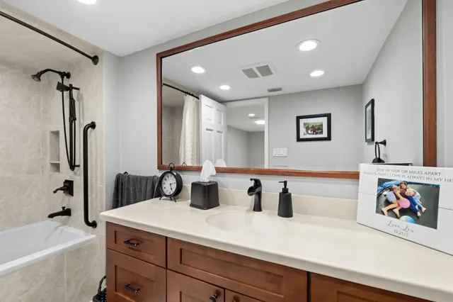 a bathroom with a toilet a double vanity sink and a mirror