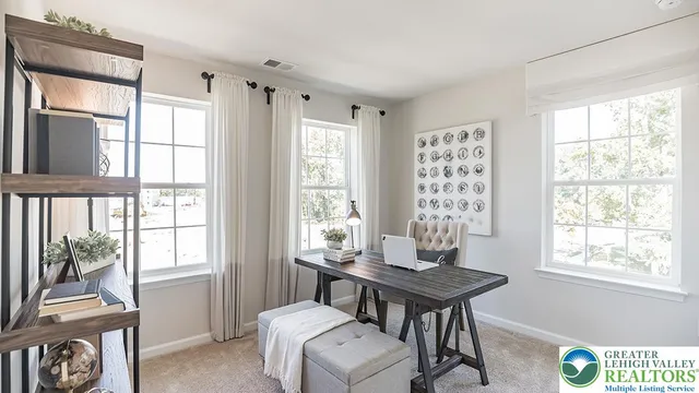a view of a workspace with furniture and a window