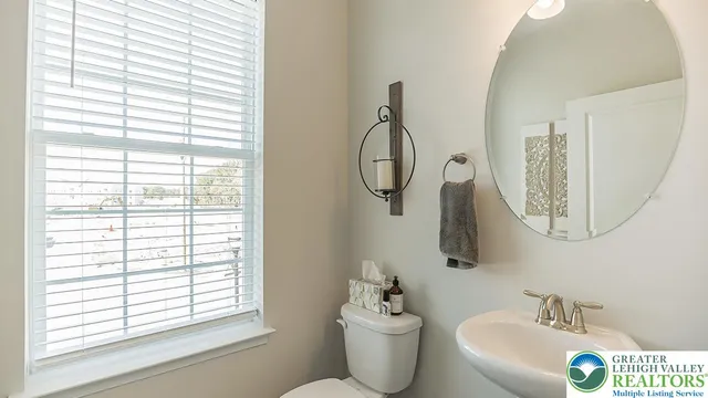 a bathroom with a sink and mirror with window