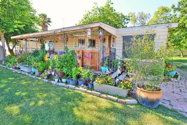 a front view of a house with a yard and potted plants