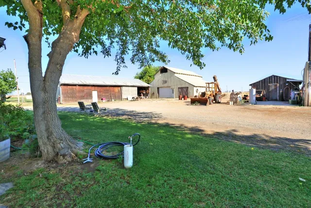 a view of a house with backyard and trees