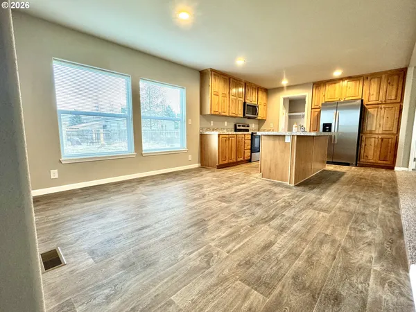a view of a kitchen with furniture and wooden floor