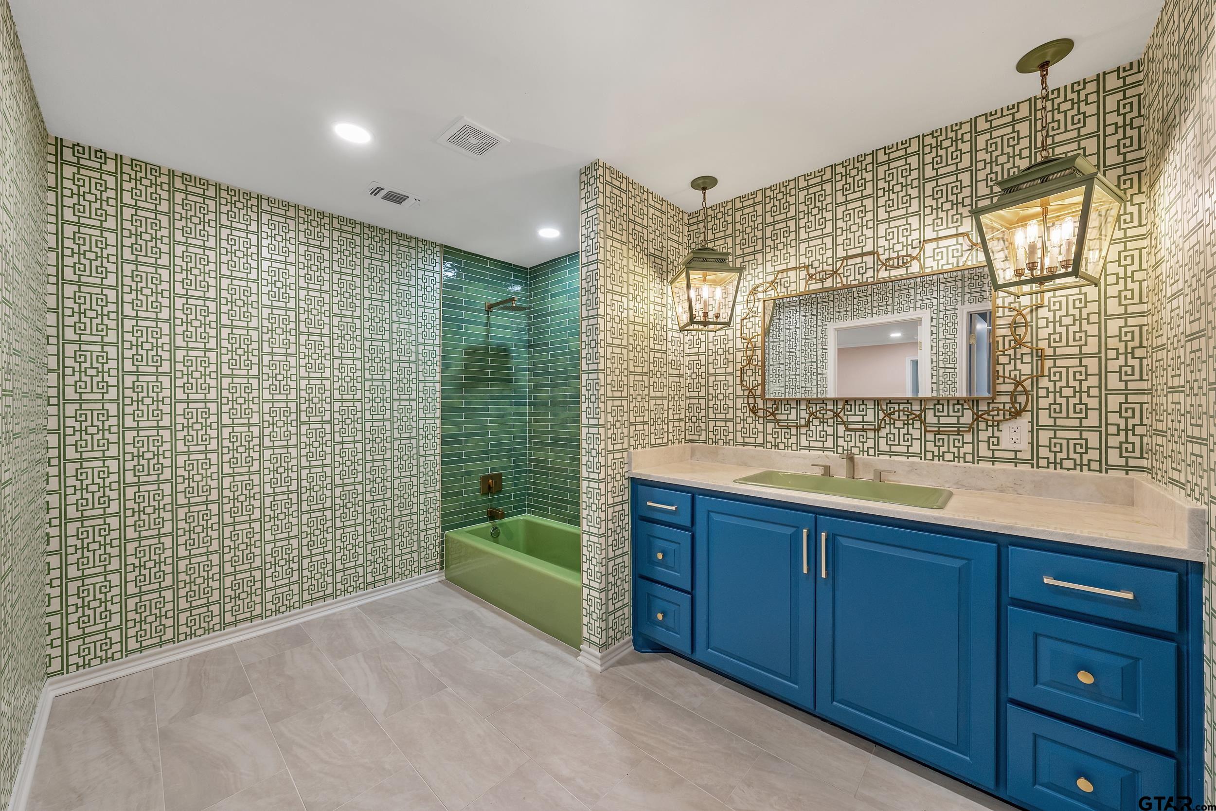 606 Tremont Place Tyler, TX 75701 - Photo 37 of 48 a bathroom with a sink a mirror and a bathtub