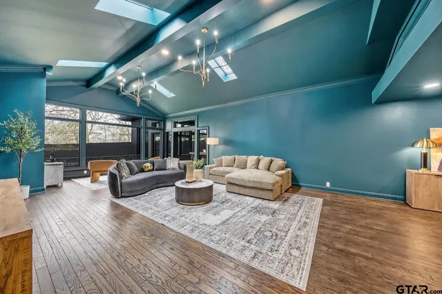 a living room with furniture a chandelier and a rug