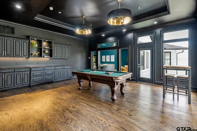 a living room with furniture a chandelier and a wooden floor