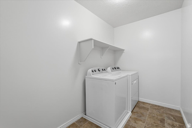 1218 Moonlight Drive Elk Ridge, UT 84651 - Photo 20 of 44 Laundry area with washing machine and clothes dryer and a textured ceiling