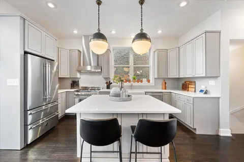 a kitchen with stainless steel appliances a stove a sink a microwave a refrigerator and cabinets
