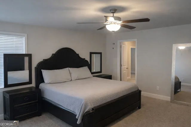 a bedroom with a bed and a flat tv screen on dresser