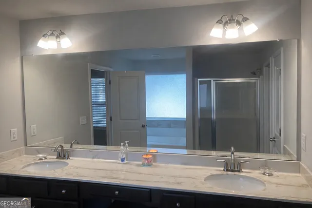 a bathroom with double vanity sinks and a mirror
