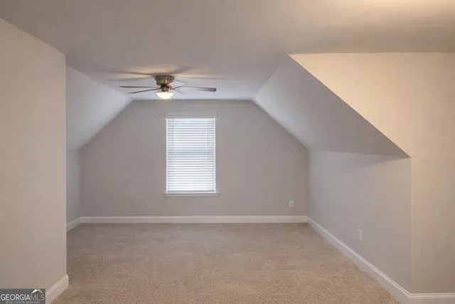 an empty room with a window and a ceiling fan