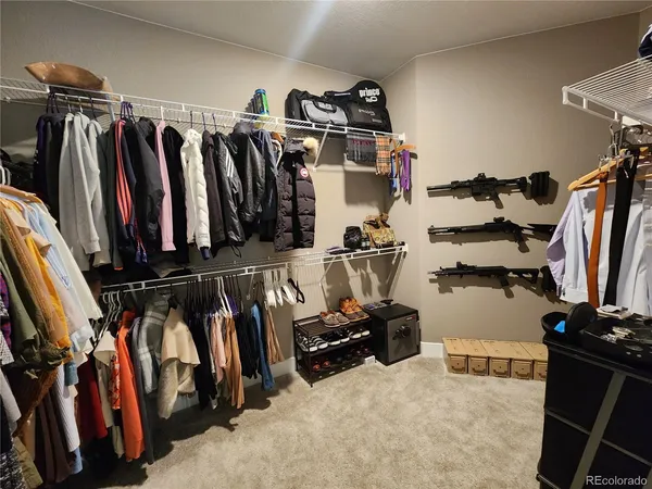 a view of walk in closet with clothes and shoes