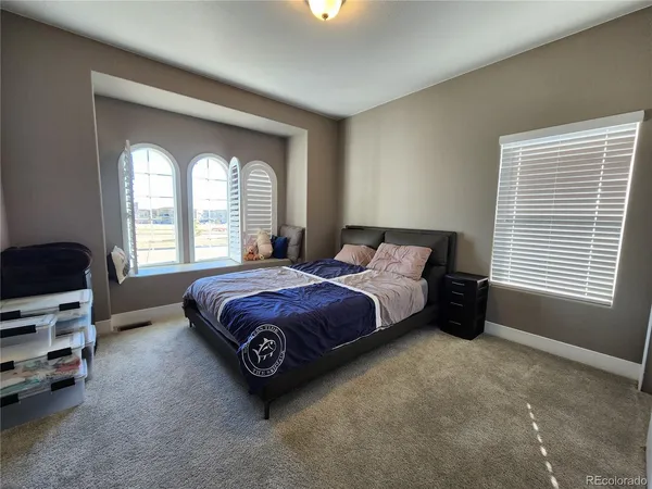 a spacious bedroom with a bed and a window