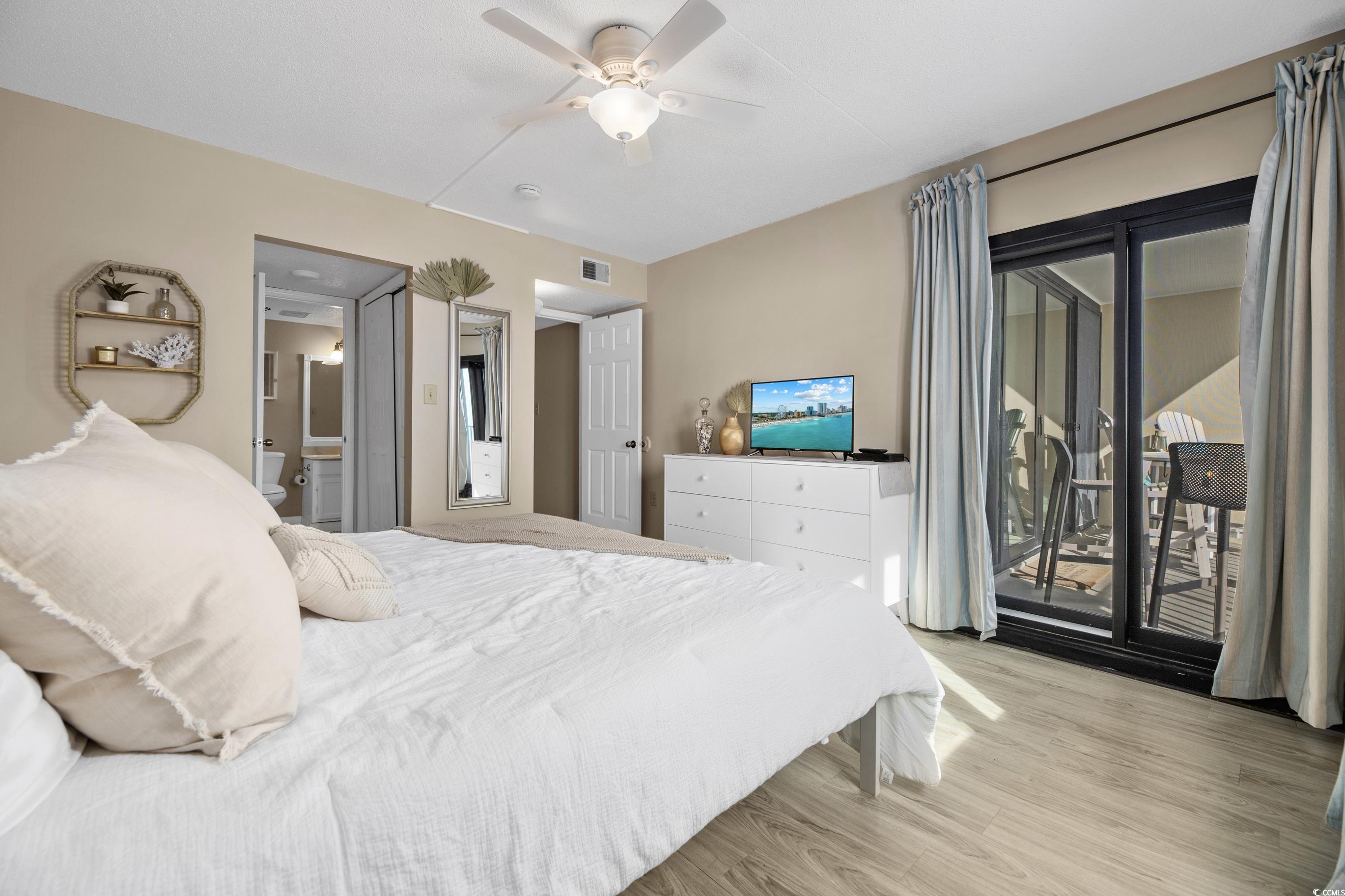 1108 North Waccamaw Drive, Unit 304 Murrells Inlet, SC 29576 - Photo 13 of 34 Bedroom featuring access to exterior, light wood-style floors, a ceiling fan, and ensuite bathroom