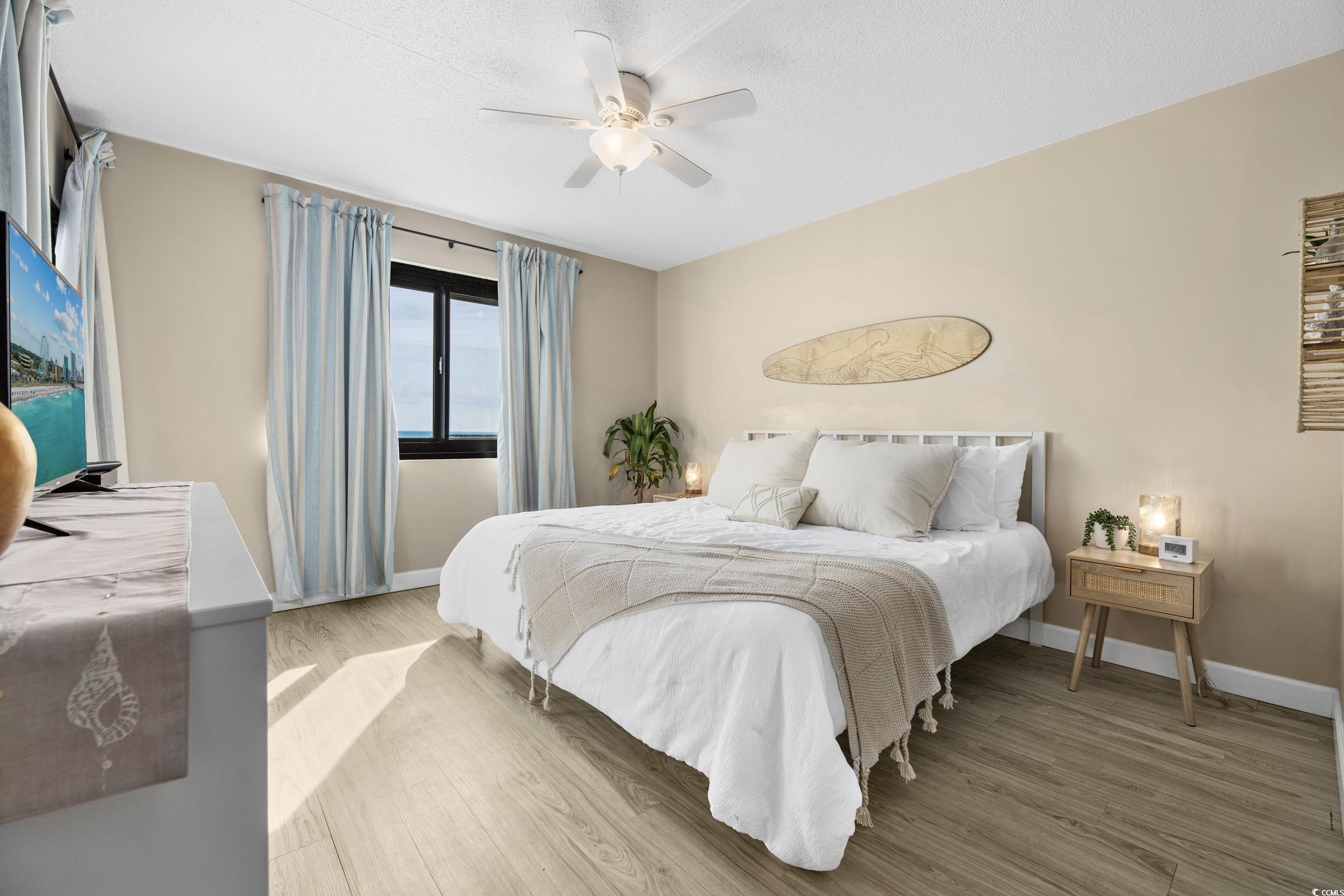 1108 North Waccamaw Drive, Unit 304 Murrells Inlet, SC 29576 - Photo 14 of 34 Bedroom with wood finished floors, a ceiling fan, and a textured ceiling