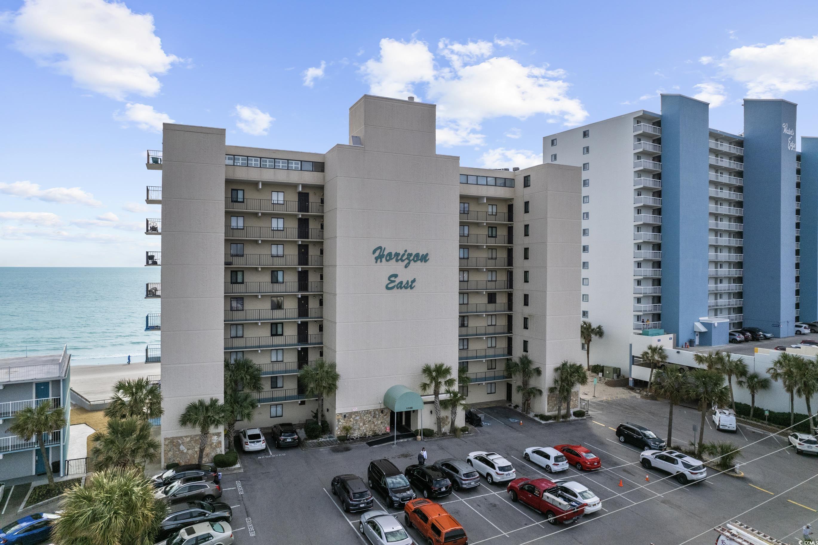 1108 North Waccamaw Drive, Unit 304 Murrells Inlet, SC 29576 - Photo 2 of 34 View of apartment building / complex with uncovered parking and a water view
