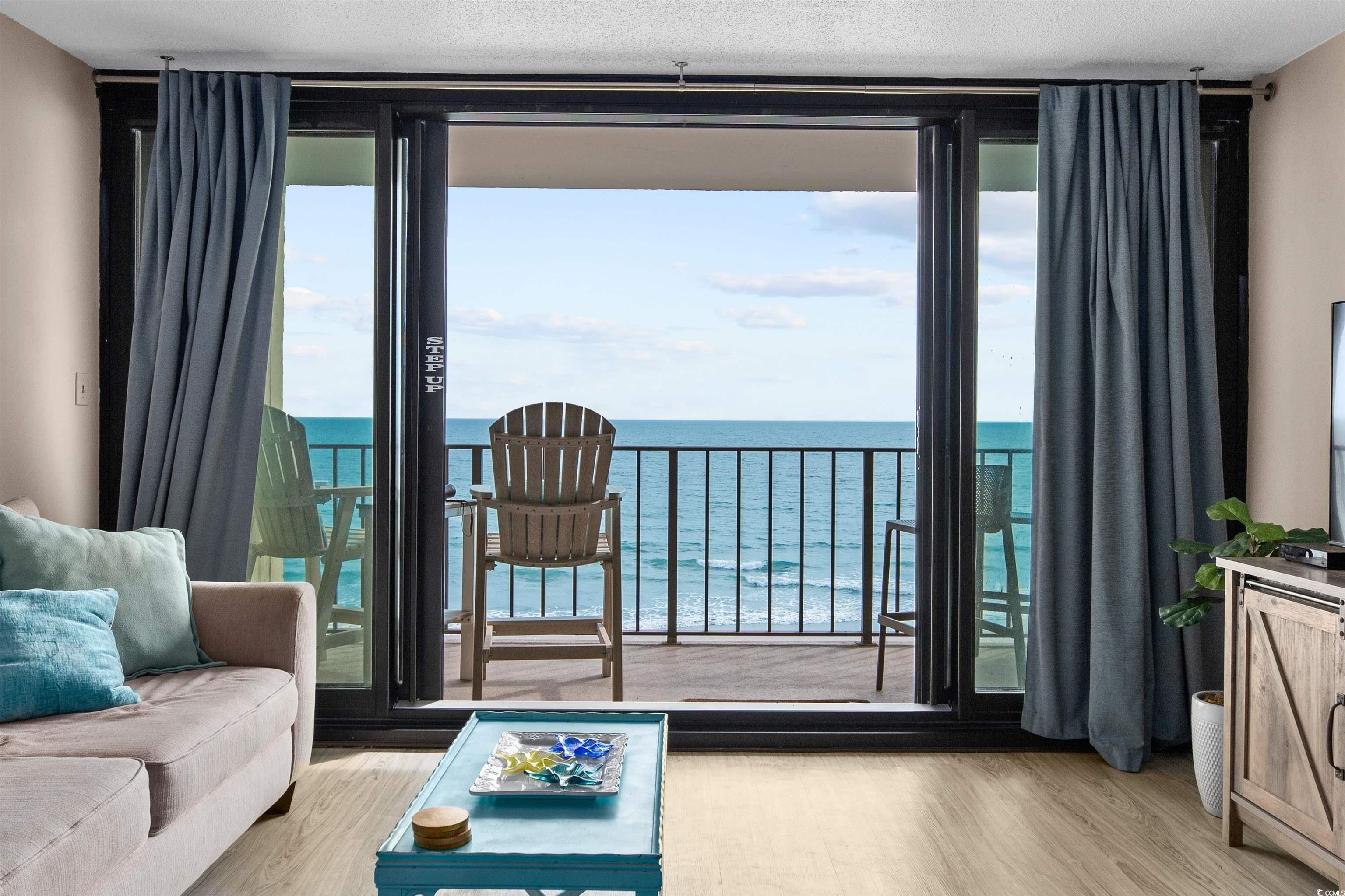 1108 North Waccamaw Drive, Unit 304 Murrells Inlet, SC 29576 - Photo 3 of 34 Living area featuring expansive windows, light wood-style floors, and a water view