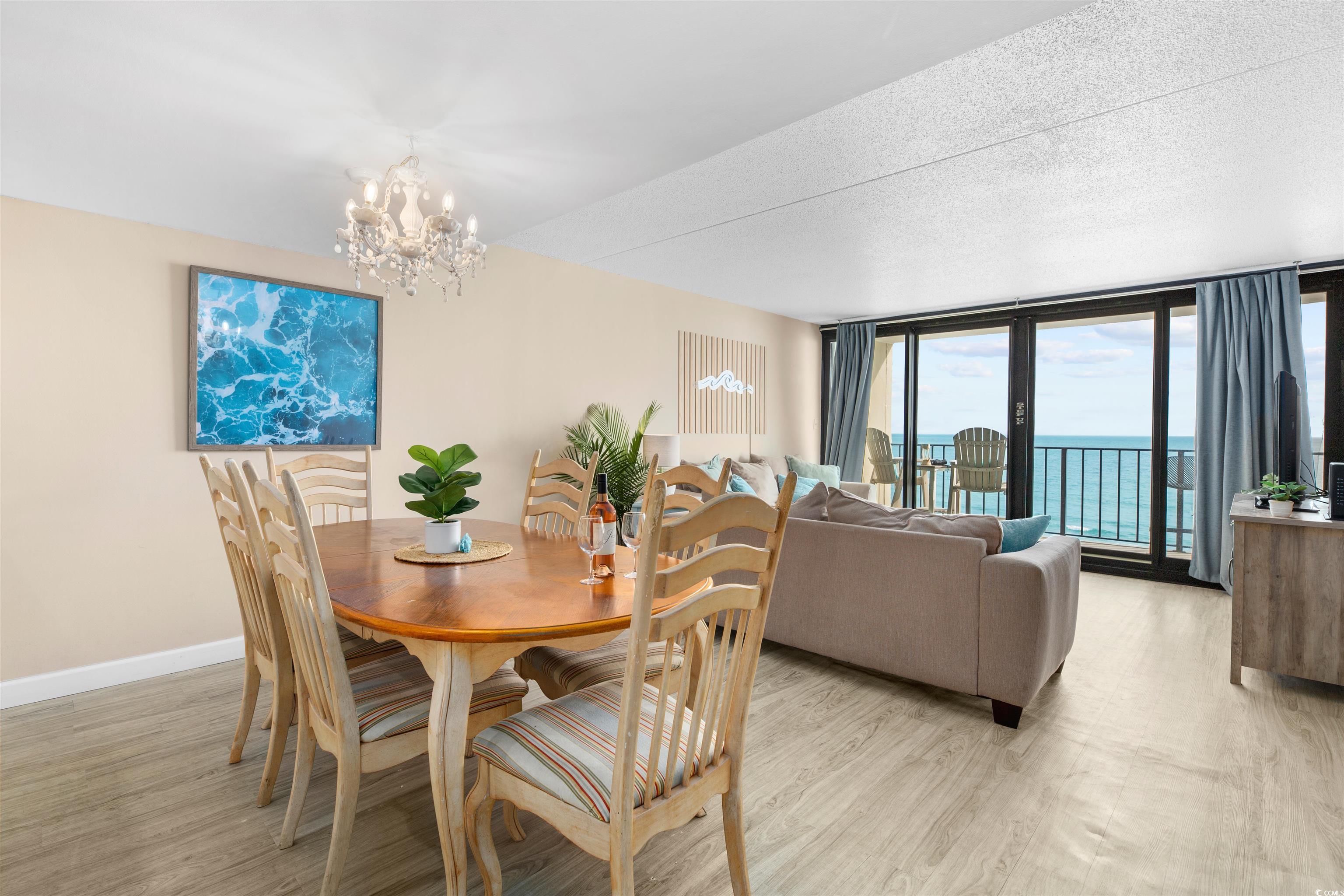 1108 North Waccamaw Drive, Unit 304 Murrells Inlet, SC 29576 - Photo 5 of 34 Dining room featuring floor to ceiling windows, light wood-style flooring, and a chandelier