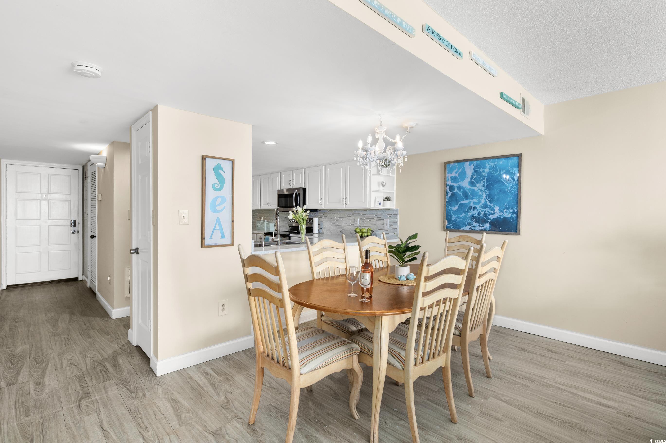 1108 North Waccamaw Drive, Unit 304 Murrells Inlet, SC 29576 - Photo 6 of 34 Dining room with light wood finished floors and a chandelier