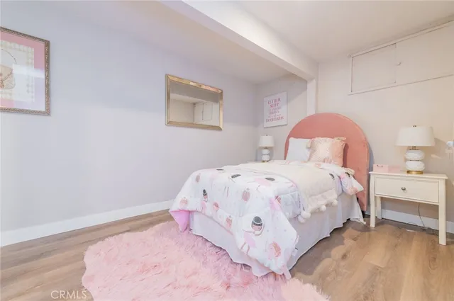 a bedroom with a bed and a lamp on dresser
