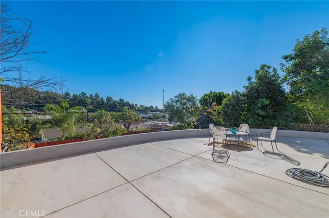 a view of a patio with a table and chairs with wooden fence