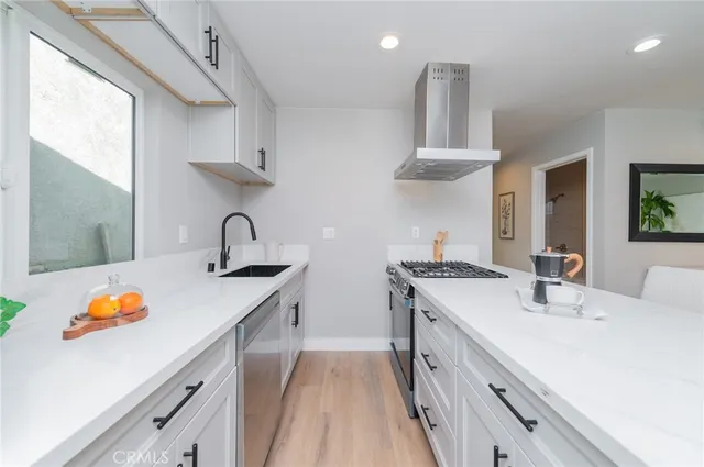 a kitchen with stainless steel appliances a sink stove and cabinets