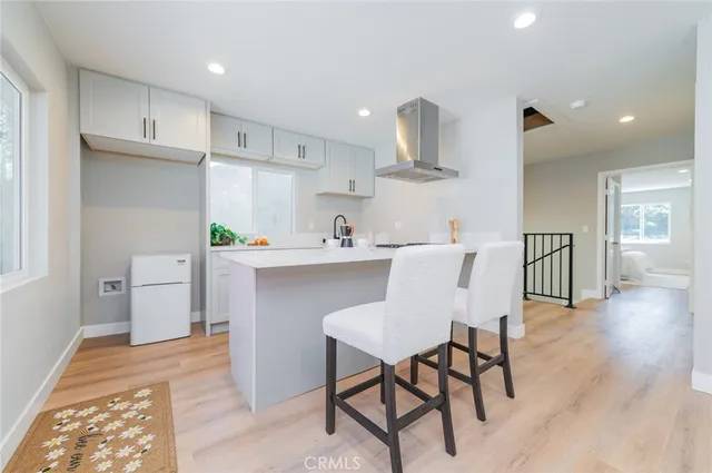 a kitchen with a table chairs refrigerator and microwave