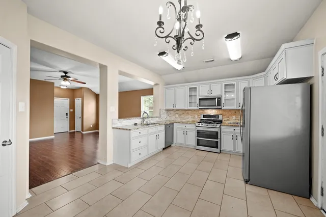 an empty room with a ceiling fan and window