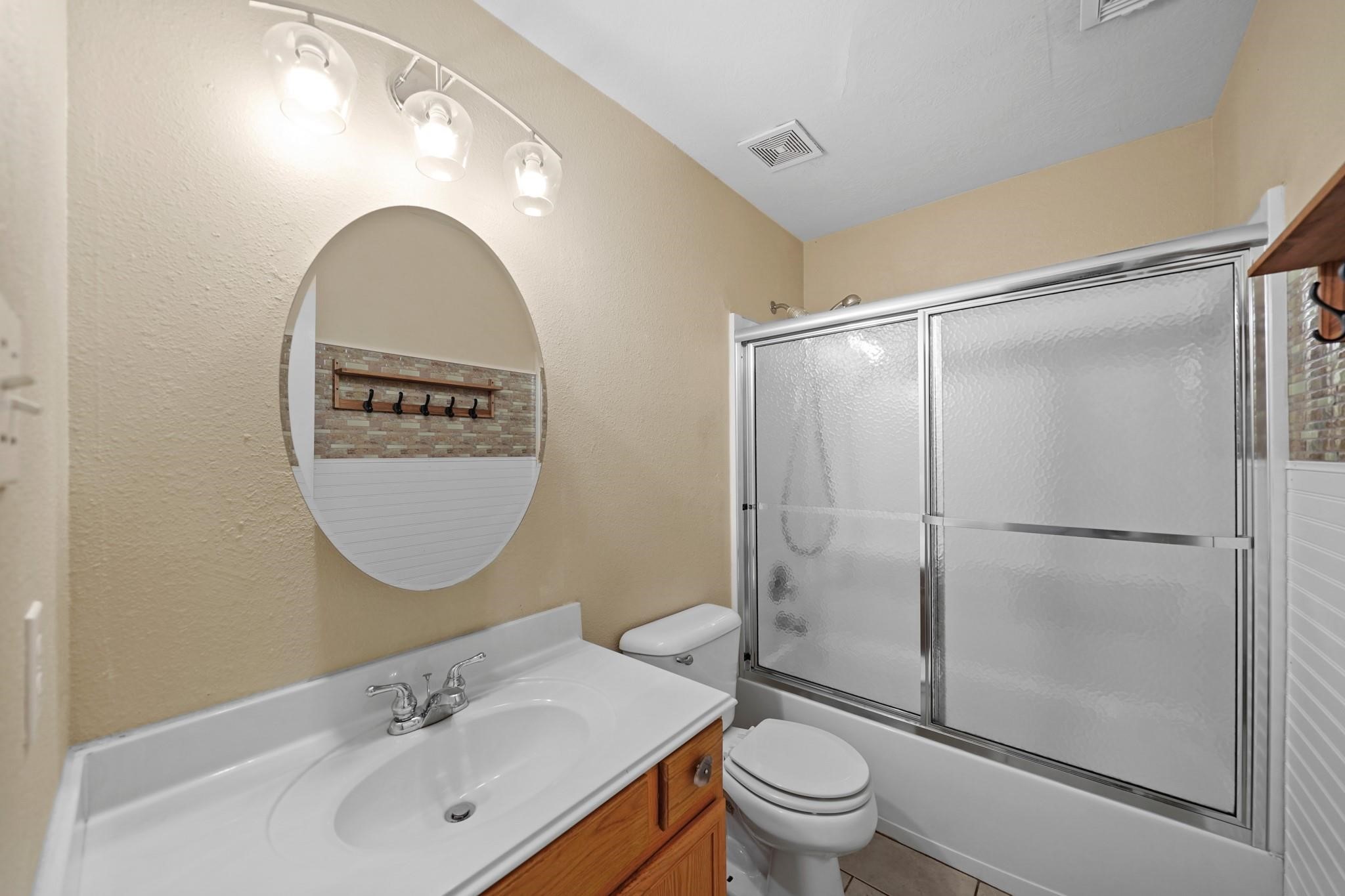 2813 Waterside Trail Pearland, TX 77584 - Photo 19 of 25 a bathroom with a sink a mirror a toilet and a shower
