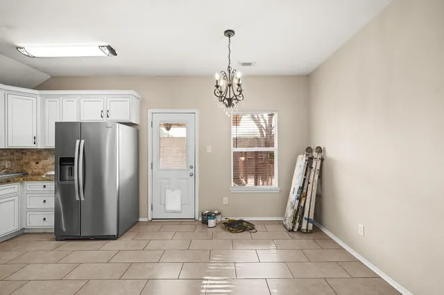 a kitchen with stainless steel appliances granite countertop a refrigerator and a stove top oven