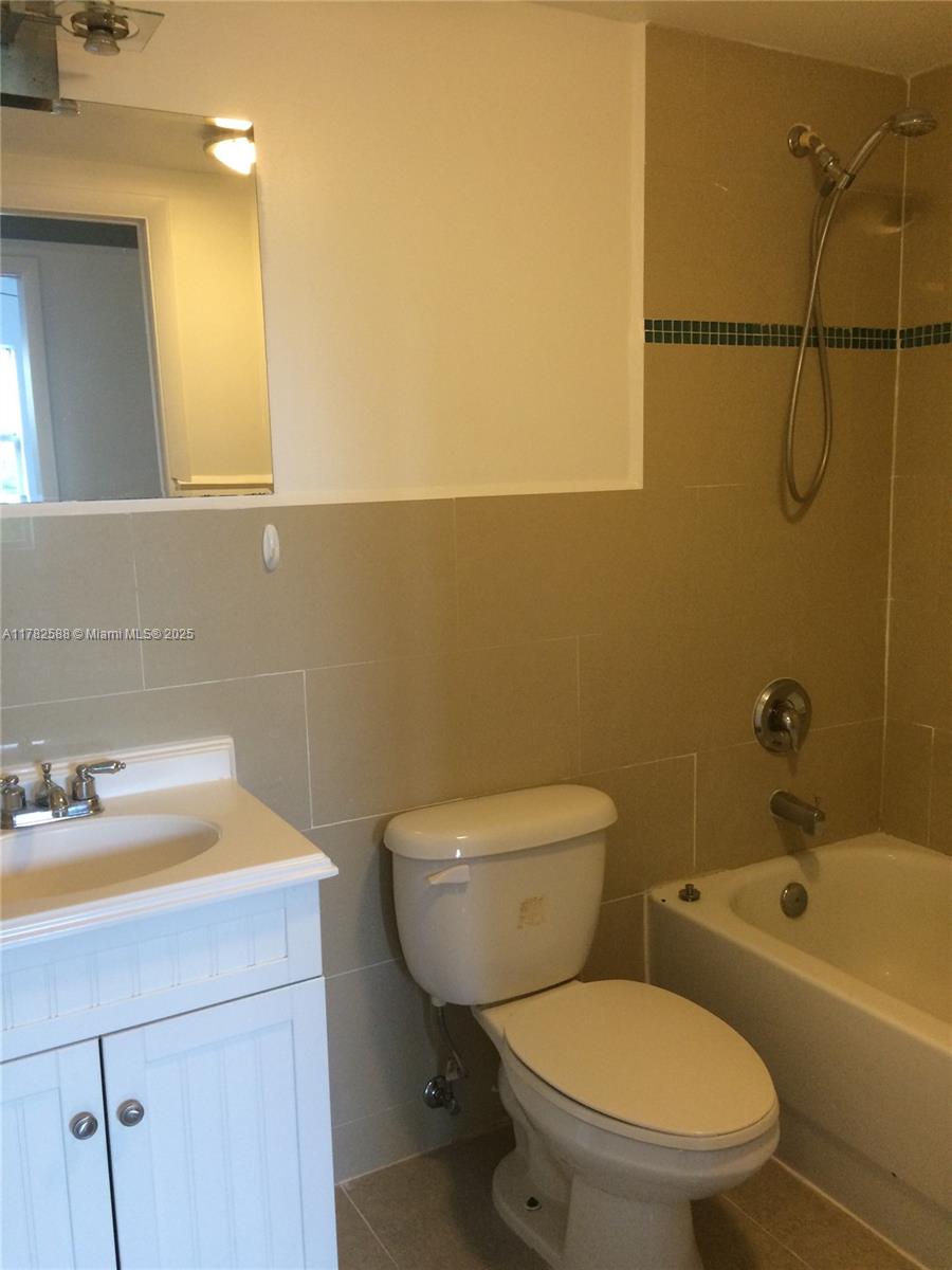 7025 Rue Granville, Unit 3 Miami Beach, FL 33141 - Photo 15 of 21 a bathroom with a sink mirror vanity and toilet